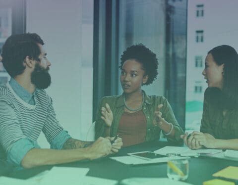 Panel of three employees discussing at a table